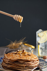 buckwheat pancakes with honey and hazelnuts on an old plate