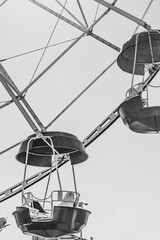 Ferris wheel booths in black and white image. The cabin of the Ferris wheel against the sky on top.Background image of the Ferris wheel.