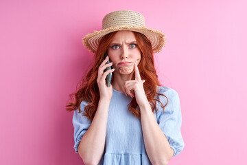 woman talk on phone dissatisfied by news, isolated on pink background