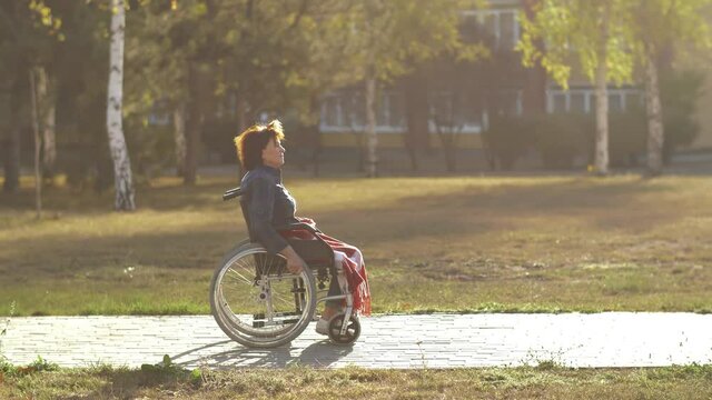 Woman in a wheelchair riding in the park
