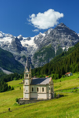 Fototapeta na wymiar Mountain landscape along the road to Stelvio pass at summer. Church