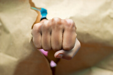 a man showing his Fist through a broken poster. 