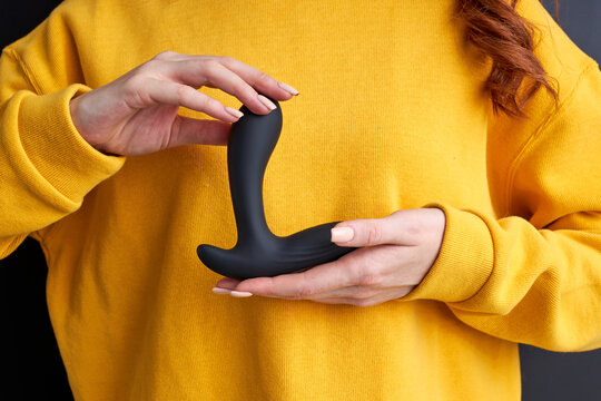woman holding black vibrator in hands, representing it. sexual pleasure concept. created to exploring your erogenous zones, strengthening vaginal muscles