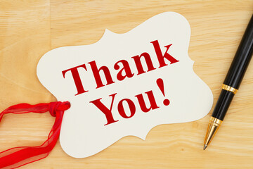 Thank you note for a present message on a gift tag with a pen