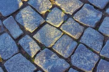 Fragment of an old granite pavement made of square blocks