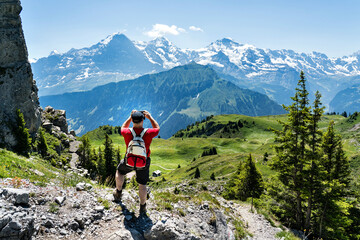 Mann fotografiert auf einer Wanderung im berner Oberland die schweizer Alpen mit dem Smartphone. Wandern, Mobil, Telefon, Handy, Foto, wandern, Schweiz