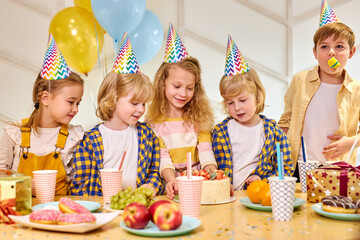 caucasian group of children friends celebrating birthday, little kids have birthday party, congratulating friend, have fun and entertainment