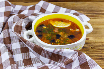 Traditional russian hodgepodge soup on a wooden table