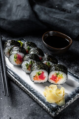Sushi rolls hosomaki with salmon, avocado and tuna. Black background. Top view