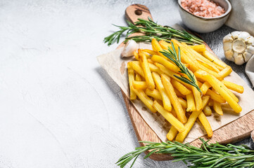 Potatoes fries, French fries with rosemary on a cutting board. White background. Top view. Copy space