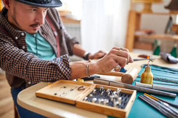 Fototapeta premium goldsmith repairing jewellery using goldsmith's tools. for this work it takes precision and patience. tradition, luxury, jewelry