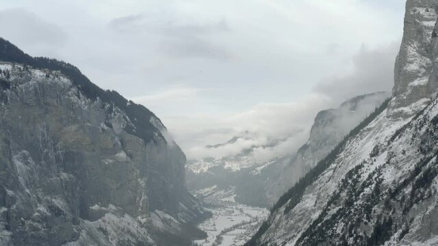 Drone Aerial of Lauterbrunnen surrounded by the Mountain Eiger in the swiss alps. The winter in Switzerland has begun and the ski and holiday season has started. Heavy snow in this resort village.