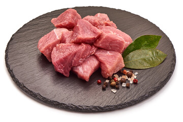Raw pork pieces on a stone plate, ingredients for goulash, isolated on white background