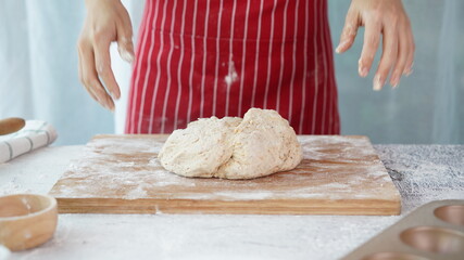 Whole wheat bread from homemade whole grain dough made by woman with red apron. Healthy pastry with many grains.