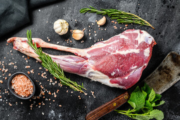 Whole lamb leg. Raw organic meat. Black background. Top view