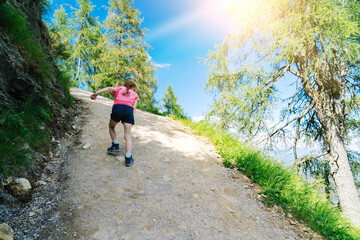 Obraz premium Children hiking on beautiful summer day in alps mountains Austria, resting on rock and admire amazing view to mountain peaks. Active family vacation leisure with kids. Outdoor fun and healthy activity