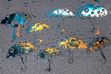 Rain. Raindrops fall down against the gray background with blue, white and yellow umbrella...