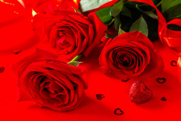 Red roses and decor in the shape of a heart on a red background.