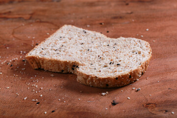Brown slide whole wheat bread on cutting wood. Tasty and healthy pastry of European menu. Famous food and dessert  on dish as breakfast.