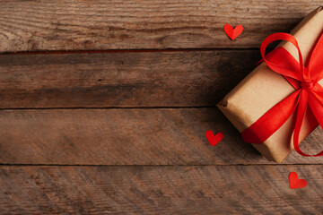 paper Holidays gift and red hearts on wooden background, Valentines day greeting card