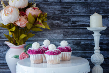 made dish of delicious cupcakes with white cream decorated with ripe strawberries on a gray