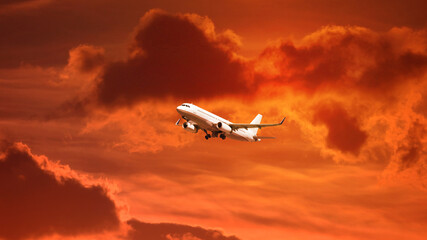 Zoom photo of modern passenger airplane flying towards sunset with cloudy sky and beautiful golden colors