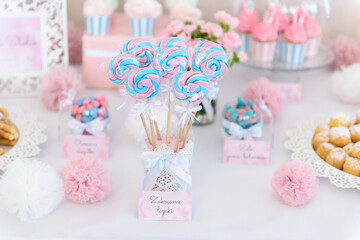 Twisted lollipops and other sweets on a candy bar at the wedding party