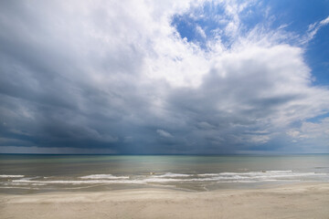 Fototapeta na wymiar storm clouds move in over the beach and water atlantic ocean