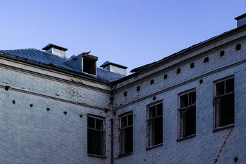Empty windows of an abandoned old school building.