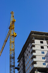 Fototapeta na wymiar Under construction high-rise building with construction cranes near.