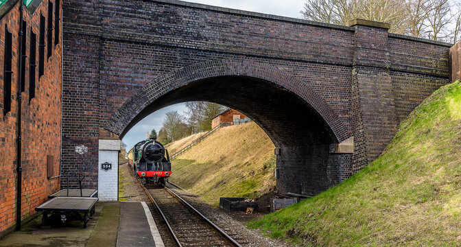 A train approaching a bridge at a station in Leicestershire, UK