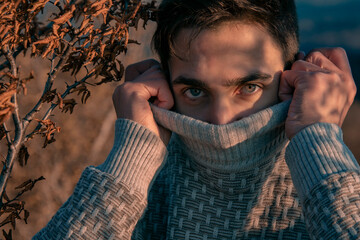 Young guy in a sweater. Mountain landscape. Portrait photographs. Emotions and feelings.