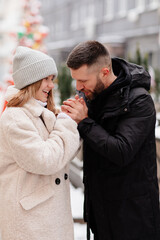 Dad and daughter walk winter streets and warms her hands with breath.