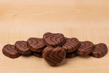 Close up view of chocolate cookies in heart shape on wooden background. Valentines day concept.  