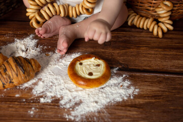 small children's feet in flour on a wooden background