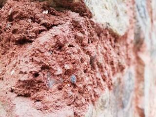 Close up of a red stone, another brick in the wall. 
