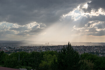 Obraz premium The evening sun shines on the city through the thick clouds (Brno, Czech republic)
