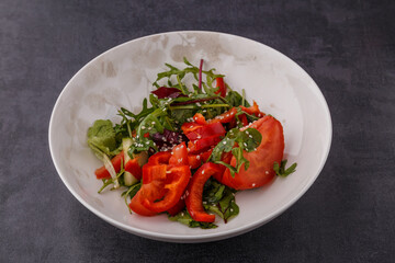 Vegan Spring Salad. Tomato, lettuce, dressing, bell peppers and avocados. Fork with vegetables and salad.