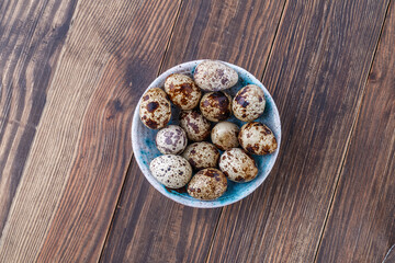 Quail eggs on the wooden plate. Quail eggs can be consumed by frying or boiling. In Indonesia quail eggs called telur puyuh.