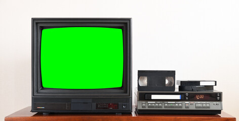 Old black vintage TV with green screen to add new images to the screen, VCR on wallpaper background from the 1980s, 1990s, 2000s.