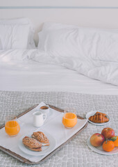 healthy breakfast on a hotel bed. The background is clear and smooth. There is a lot of colorful fruit and juice.