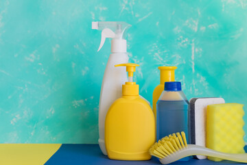 Colorful cleaning set for different surfaces in kitchen, bathroom and other rooms. Empty place for text or logo on pink background. Cleaning service concept. Early spring regular clean up. Top view.