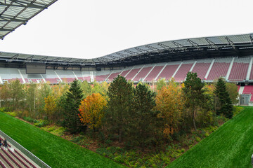 A forest planted in the middle of the football stadium in Klagenfurt, Austria. The pitch turf resembles the forest, changing colors for autumn. Many different tree sorts. Modern installation. Nature © Chris