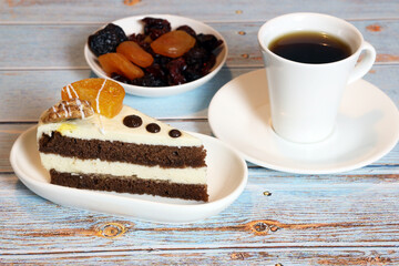a slice of delicious cake, dried fruits and a cup of coffee on the table