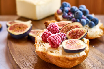 Croissant toast with butter and figs. French dip sandwich with berries raspberries for Breakfast. High quality photo