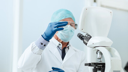 Fototapeta premium scientist in with an ampoule sitting at a laboratory table .