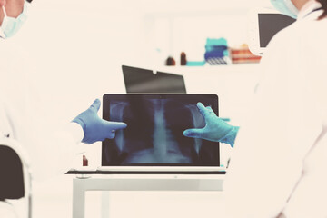 attending doctors use a laptop to check the x-ray