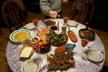 Table setting on Christmas eve. The candle is being lightened up. 
