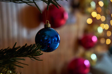 Colorful Christmas tree decorations with lights in the background