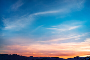 Beautiful panoramic sunset over the mountains silhouette.